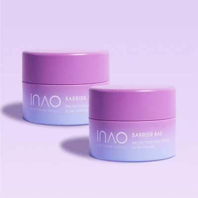 Zwei Lavendeltiegel der INAO by essence Barrier Bae Protection Rich Cream sind auf hellviolettem Hintergrund abgebildet. Das schlichte Design mit weißem Text stärkt Ihre Hautbarriere und macht sie perfekt für starke, gesunde Haut.