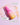 Eine rosa-gelbe Flasche INAO by essence Bright Sense Hydra Plump & Glow Serum mit Hyaluronsäure steht auf einem hellrosa Untergrund, Serum ist darüber verschüttet. Deutsche Etiketten bescheinigen, dass es vegan und rein ist, Feuchtigkeit spendet und aufhellt und für alle Hauttypen geeignet ist.