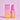 Eine rosa und eine orange Flasche INAO Bright Sense Hydra Plump & Glow Serum mit 2 % Vitamin C stehen neben der passenden Schachtel, beide vor einem hellrosa Hintergrund.
