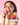 Eine lächelnde Frau hält ein rotes Clean Skin x JUICY BOMB Gummibärchen vor den Mund und in der anderen Hand ein INAO by essence Tiegel. Textblasen sagen „vegan“, „2 Gummies am Tag“ und heben Biotin & Zink hervor. Der Hintergrund ist rosa.