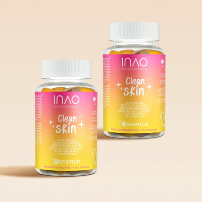 Zwei Flaschen INAO von essence Clean Skin Gummies mit rosa, orangefarbenen und gelben Farbverlaufsetiketten und weißen Deckeln. Die Etiketten betonen Ceramide und Vitamin-Komplex für ihre Schönheitsvorteile. Die Flaschen stehen vor einem neutralen beigen Hintergrund.