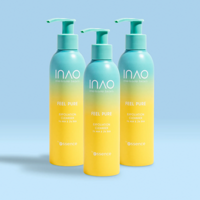 Drei Pumpflaschen des INAO by essence Feel Pure AHA & BHA Exfoliation Cleanser stehen auf einer hellblauen Fläche. Die Flaschen in Blau und Gelb mit grünen Pumpverschlüssen und weißem Text stehen vor einem blauen Hintergrund mit Farbverlauf.