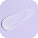Ein cremig-weißer Klecks Lotion oder Creme wird auf einer glatten, hellvioletten Oberfläche verteilt, wodurch eine weiche und glänzende Textur entsteht.