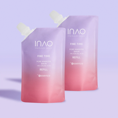Vor einem hellvioletten Hintergrund stehen zwei Beutel mit pastellfarbenem Farbverlauf und der Aufschrift „INAO by essence Fine Time Pore Minimizer Serum Refill“ mit Ausgießern oben, die für unreine Haut entwickelt wurden.