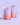 Vor einem hellvioletten Hintergrund stehen zwei Beutel mit pastellfarbenem Farbverlauf und der Aufschrift „INAO by essence Fine Time Pore Minimizer Serum Refill“ mit Ausgießern oben, die für unreine Haut entwickelt wurden.