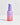 Eine Flasche Hautpflegeserum mit Farbverlauf in Lila und Rosa mit der Aufschrift „INAO Fine Time Pore Minimizer Serum mit 10 % Azelainsäure von essence“ auf hellgrauem Hintergrund.