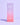 Eine rosafarbene Hautpflegeproduktschachtel mit der Aufschrift „Fine Time Pore Minimizer Serum von INAO mit 10 % Azelainsäure von essence“ steht vor einem hellvioletten Hintergrund.