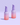 Zwei Flaschen INAO by essence Fine Time Pore Minimizer Serum mit 10 % Azelainsäure für unreine Haut in Rosa und Lila mit Farbverlauf stehen auf einer hellvioletten Oberfläche vor einem zartvioletten Hintergrund.