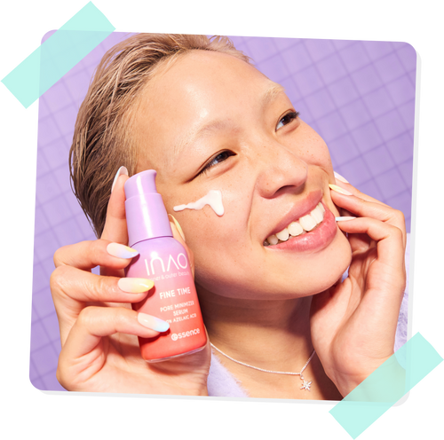 Eine lächelnde Person mit taufrischer Haut trägt Creme auf ihr Gesicht auf, während sie vor einem lila gefliesten Hintergrund eine Flasche Essence Fine Time Pore Refining Serum hält.