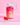 Eine Flasche INAO von essence Hair YEAH! Gummies mit Biotin steht auf rosa Hintergrund, davor zwei rote Sterngummis. Das Etikett präsentiert sich im neuen Design, hebt Selen und Zink hervor und trägt den Schriftzug „Gleiche Formel“.