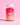 Eine Flasche INAO by essence Hair YEAH! Gummies ist vor einem rosa Hintergrund abgebildet. Die Flasche mit weißem Deckel hat ein rosa-oranges Farbverlaufsetikett und enthält rote Gummibärchen für Haare und Nägel, angereichert mit Biotin und Zink.