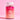 Eine Flasche INAO von essence Hair YEAH! Gummies, gefüllt mit roten Gummivitaminen für Haare und Nägel, steht vor einem rosa Hintergrund. Das Etikett wirbt mit Vorteilen wie Biotin, Selen und Zink.