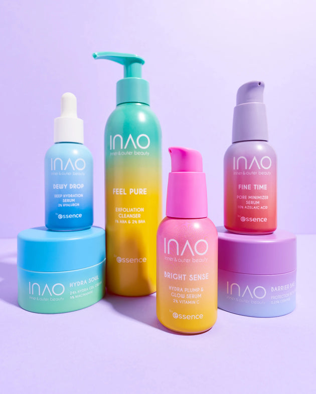 Sechs farbenfrohe Flaschen und Tiegel von INAO by essence stehen auf einem violetten Untergrund. Das Skincare Lover Sparset enthält Seren, Cremes und einen Peeling-Reiniger in leuchtenden Blau-, Grün-, Gelb-, Pink- und Violett-Verpackungen.