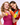 Zwei lächelnde Frauen mit buntem Make-up und leuchtenden Outfits posieren zusammen und halten INAO-Flaschen mit Essenzen in der Hand: eine rosa Clean Skin Gummies, die andere gelb-blaue Feel Fresh – und fangen so den lebhaften Slay More Sparset-Geist ein.