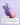 Eine Flasche Get Stronger Sparset von INAO by essence steht auf einer hellvioletten Oberfläche, darunter ist Serum verschmiert. Der Text weist auf Schritt 3 hin: Tragen Sie das Hydration Serum auf und vermeiden Sie dabei die Augen- und Lippenpartie, um Ihre Hautbarriere zu unterstützen.