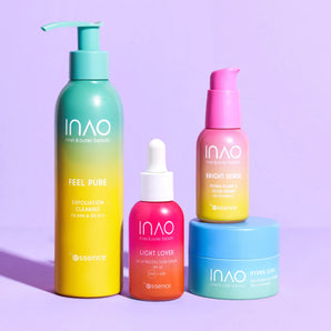 Vier farbenfrohe INAO by essence Glow Bright Sparset-Hautpflegeprodukte – ein Peeling-Reiniger, ein Glow-Serum, LSF 50 und mehr – sind auf einem violetten Hintergrund angeordnet: eine Pumpflasche, eine Tropfflasche, ein Pumpspender und ein Tiegel mit leuchtender Verpackung.