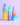 Vier farbenfrohe INAO by essence Anti-Unreinheiten mit INAO-Produkten – Feel Pure, Moist Mist, Fine Time und Hydra Soul – sind auf einer violetten Fläche mit lavendelfarbenem Hintergrund arrangiert. Das Display enthält sowohl Flaschen als auch einen Tiegel.