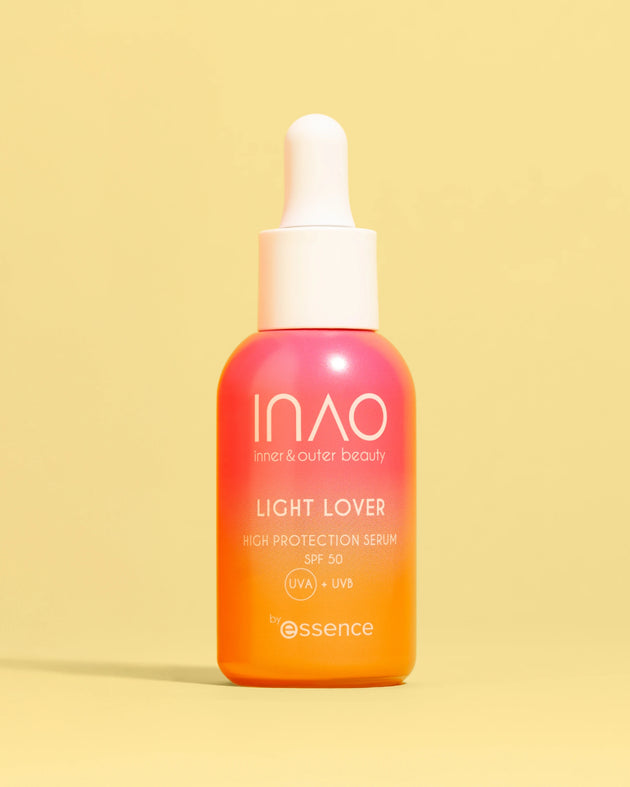 Eine Flasche INAO by essence Light Lover High Protection Serum SPF 50 mit Farbverlauf in Rosa und Orange und einer weißen Tropfkappe steht aufrecht vor einem einfarbig gelben Hintergrund – ideal für einen natürlichen Glanz.