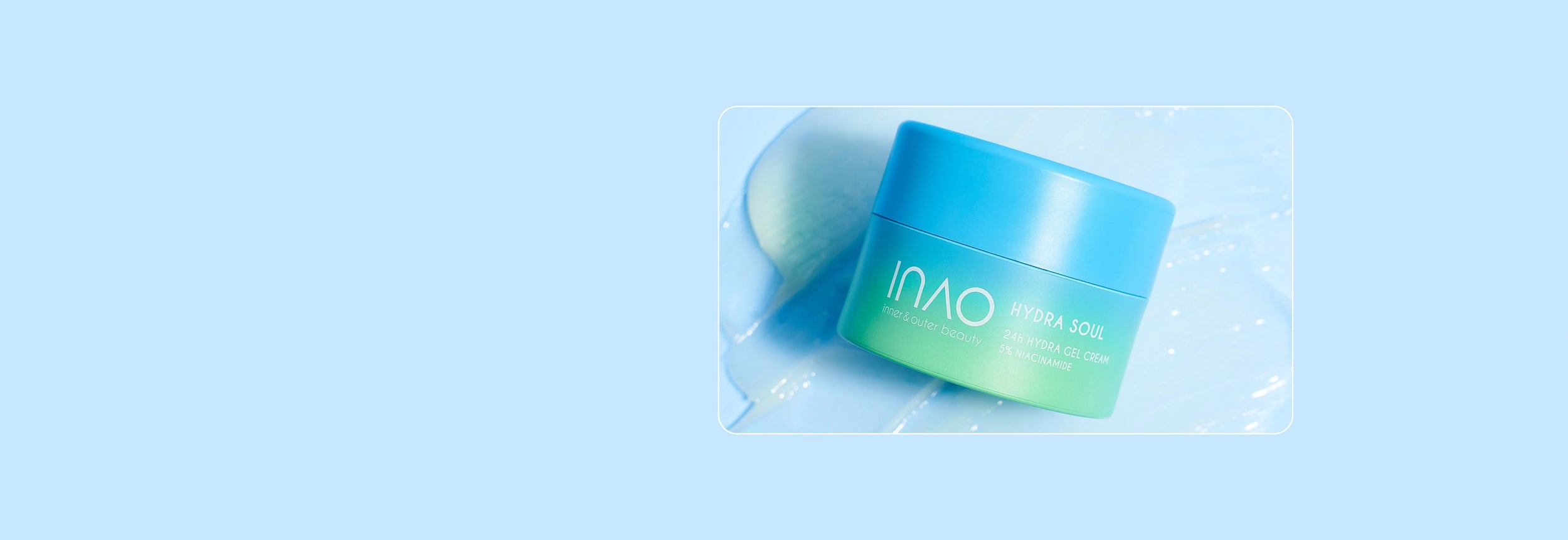Ein blau-grüner Tiegel der INAO Hydra Soul 24H Hydro Gel Cream von essence steht auf einer hellblauen Oberfläche mit glänzender Textur. Der Hintergrund ist hellblau, unten rechts befindet sich das essence-Logo.