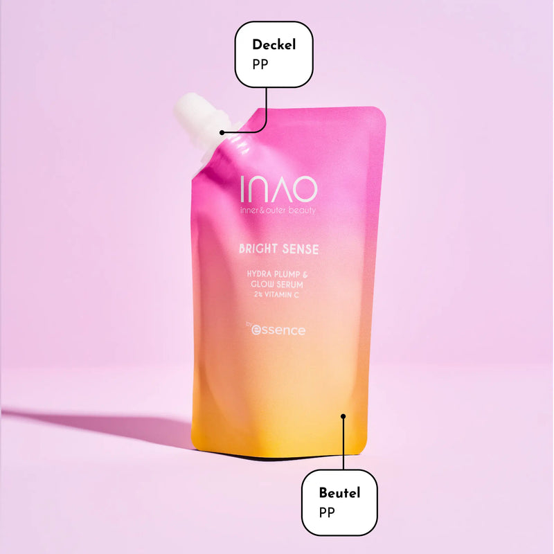 Ein rosa-orangefarbener Farbverlaufsbeutel mit der Aufschrift „INAO BRIGHT SENSE Hydra Plump & Glow Serum“ steht aufrecht auf rosa Hintergrund. Die Beschriftung „Deckel PP“ (Verschluss) und „Beutel PP“ (Beutel) weist auf das verwendete Material hin.