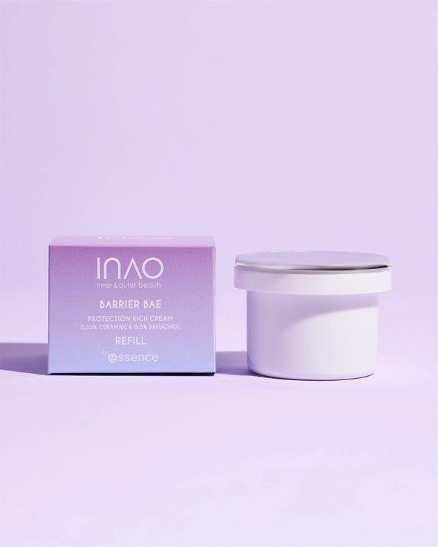 Eine lila-weiße Box und ein passender Nachfüllbehälter mit „INAO by essence Barrier Bae Protection Rich Cream Refill“ ruhen auf einem pastellvioletten Hintergrund – ideal, um Ihre Hautbarriere mit Ceramiden in dieser Premium-Gesichtscreme zu pflegen.