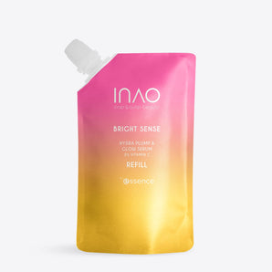 Ein Nachfüllbeutel mit rosa-gelbem Farbverlauf und der Aufschrift „Bright Sense Hydra Plump & Glow Serum Refill“ von INAO by essence, mit Hyaluronsäure, 21 % Vitamin C und einer weißen Ausgießkappe oben links.