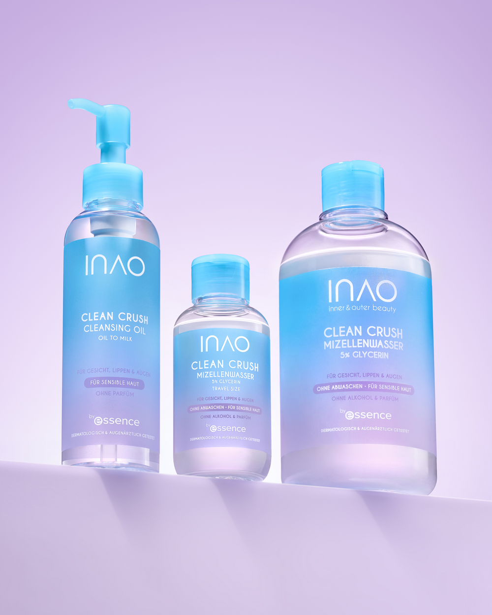 Das Clean Crush Cleansing Oil steht neben dem Clean Crush Mizellenwasser in Reisegröße und in Originalgröße auf einem lila Regal.