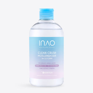 Eine durchsichtige Plastikflasche mit „INAO by essence Clean Crush Mizellenwasser“ mit blauem Verschluss und einem Etikett mit Farbverlauf enthält 5 % Glycerin. Dieser alkoholfreie und parfümfreie Make-up-Entferner eignet sich perfekt für empfindliche Haut im Gesicht, auf den Lippen und um die Augen herum.