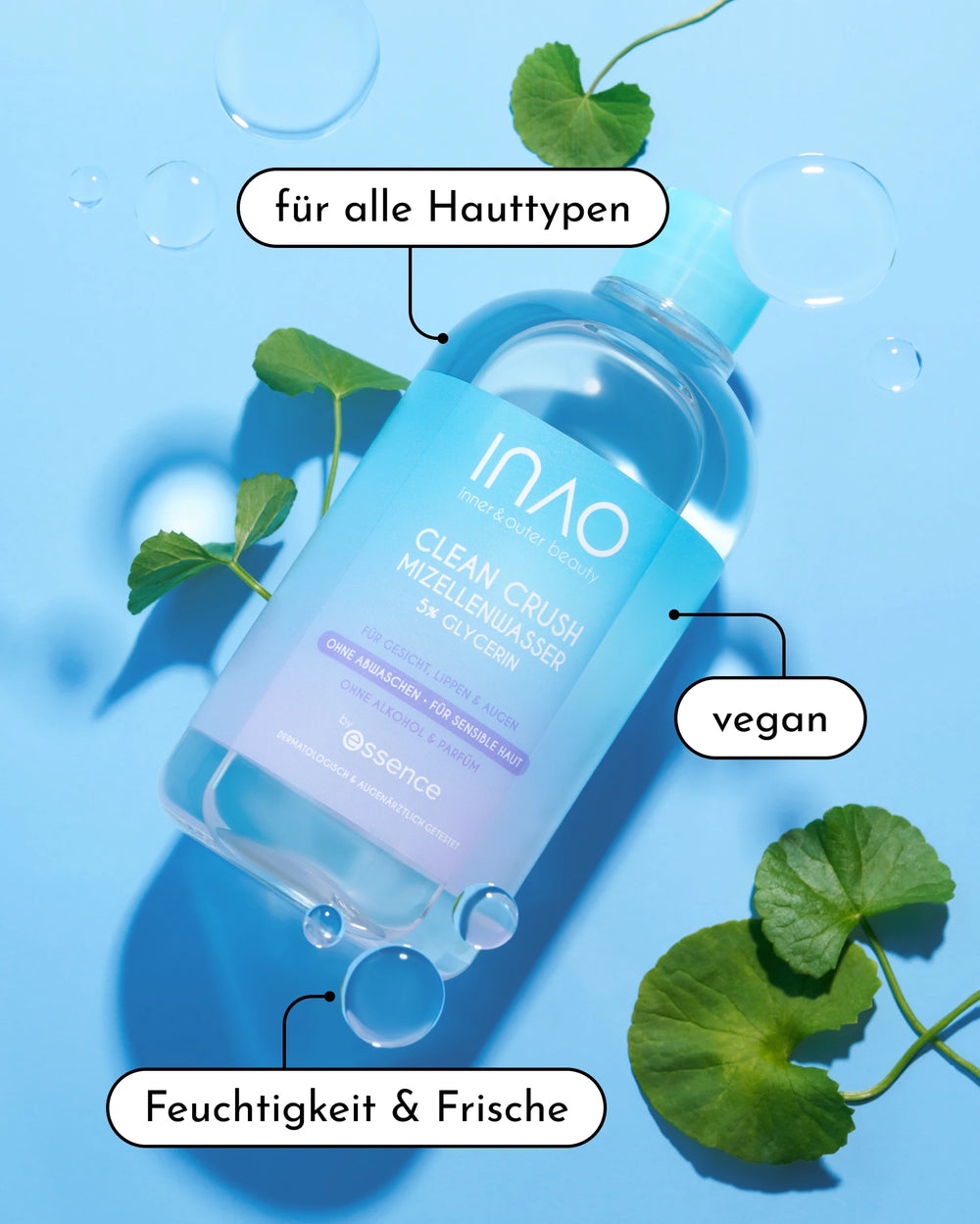 Eine klare Flasche INAO by essence Clean Crush Mizellenwasser ruht auf einer blauen Fläche mit grünen Blättern und Seifenblasen. Auf den deutschen Etiketten steht: "für alle Hauttypen", "vegan" und "Feuchtigkeit & Frische".