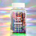 Eine Flasche der Clean Skin Community Edition Gummies von INAO by essence, angereichert mit Biotin, Zink und Ceramid, steht vor einem pastellfarbenen, schillernden Hintergrund. Das Etikett zeigt Sterne, farbenfrohe Details sowie englischen und deutschen Text.
