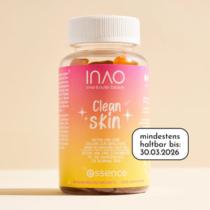 Eine Flasche INAO by essence Clean Skin Gummies mit weißer Verschlusskappe, orangefarbenem und rosafarbenem Etikett mit Farbverlauf und der Aufschrift "mindestens haltbar bis: 30.03.2026" auf beigem Hintergrund.