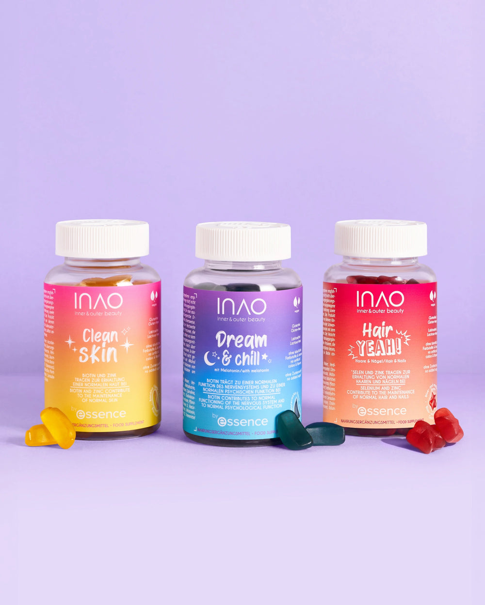 Drei leuchtende Flaschen mit INAO by essence Nahrungsergänzungsmitteln in Gummiform - Clean Skin, Dream & Chill Gummies und Hair Yeah! - stehen auf einem lavendelfarbenen Hintergrund, mit veganen Melatonin-Gummis und verschiedenen Leckereien vor jeder Flasche.
