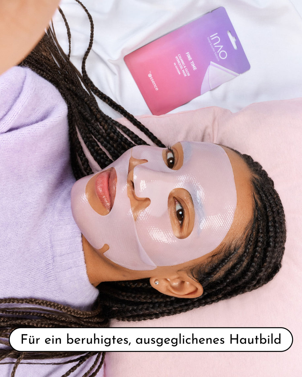 Eine Frau mit Zöpfen liegt auf einem Bett und trägt die INAO Fine Time Calming & Glow Hydrogel-Maske. Sie trägt ein hellviolettes Oberteil, neben ihr ist die rosa Verpackung der Maske zu sehen. Der deutsche Text lautet: „Für ein beruhigtes, ausgeglichenes Hautbild – Feuchtigkeitspflege für strahlende Haut.“.