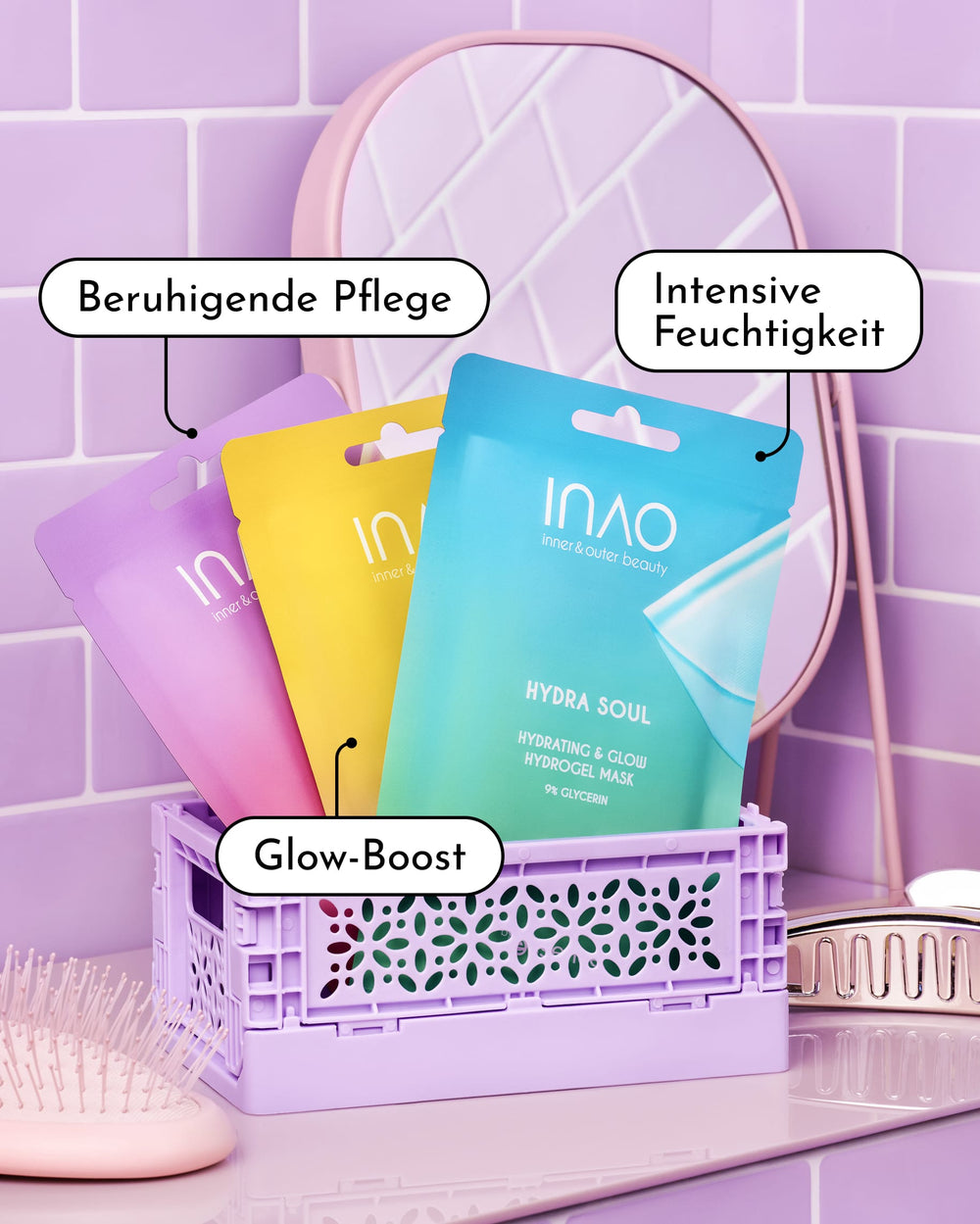 Drei farbenfrohe Packungen der INAO Fine Time Calming & Glow Hydrogel-Maske, darunter eine Hydrogel-Maske für strahlende Haut, sind zusammen mit Pinseln in einer lavendelfarbenen Kiste auf einem Waschtisch im Badezimmer angeordnet. Auf den deutschen Etiketten steht: „Beruhigende Pflege“, „Intensive Feuchtigkeit“ und „Glow-Boost“. Lila Fliesen bilden den Hintergrund und unterstreichen die wirksame Feuchtigkeitspflege, die diese Masken in Ihre Hautpflege-Routine bringen.