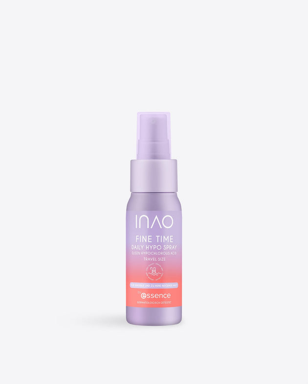 Eine kleine lavendelfarbene Flasche „INAO Fine Time Daily Hypo Spray“ in Reisegröße mit rosa und weißer Beschriftung, einer Sprühdüse und dem „Essence“-Logo; dieses Gesichtsspray beruhigt die Haut. Abgebildet vor einem schlichten weißen Hintergrund.