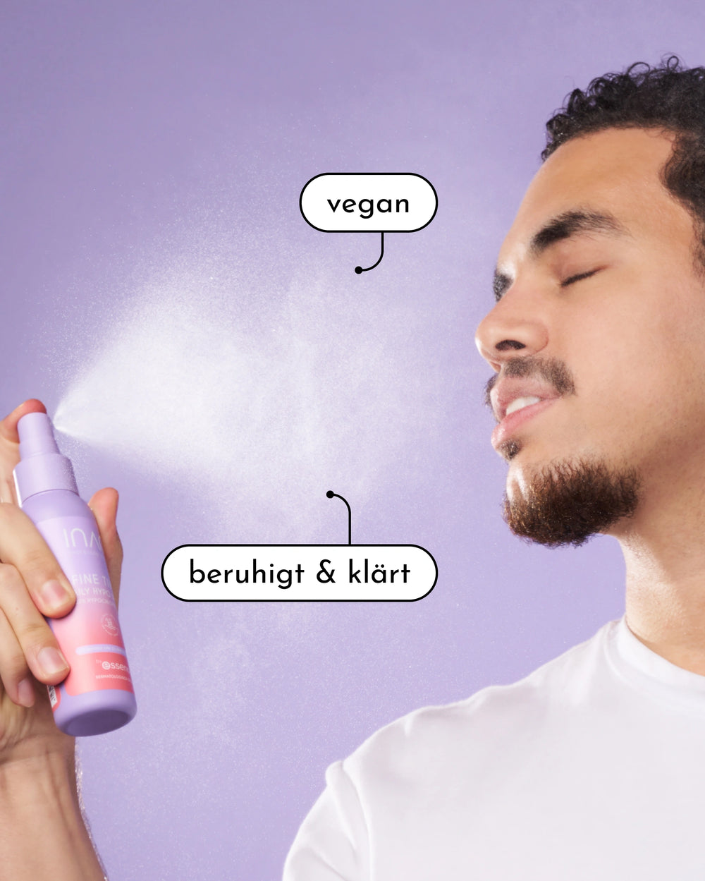 Ein Mann mit geschlossenen Augen sprüht sich das INAO by essence Fine Time Daily Hypo Spray, eine lila Flasche, vor einem lila Hintergrund ins Gesicht. Die Textblasen lauten "vegan" und "beruhigt & klärt".