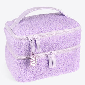 Eine weiche, lavendelfarbene INAO „Fluffy Mood“-Kosmetiktasche mit Sherpa-Struktur, doppelter Lagenausführung, zwei Fächern mit Reißverschluss, einem passenden Tragegriff und einem „INAO“-Reißverschlusszug – perfekt als stilvoller Reisebegleiter zum Aufbewahren von Make-up.