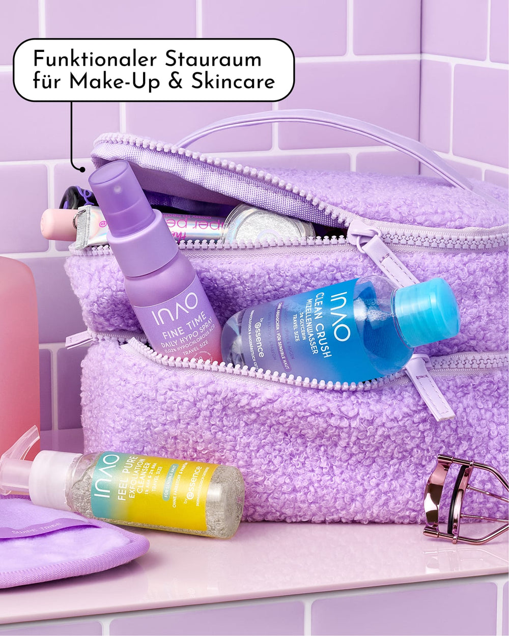 Eine lilafarbene INAO Fluffy Mood Kosmetiktasche mit Hautpflege- und Make-up-Produkten darin, platziert auf einer violetten Fliesenoberfläche. In einer Sprechblase steht: „Praktischer Stauraum für Make-up und Hautpflege – die perfekte Aufbewahrungslösung von INAO und dein zuverlässiger Reisebegleiter.“.