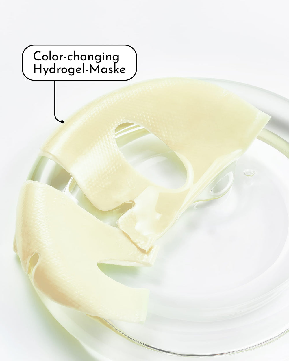 Eine durchscheinende „Glow Mode Brightening & Glow Hydrogel-Maske“ von INAO, angereichert mit Niacinamid, liegt auf einer durchsichtigen Schale. Ein Etikett mit der Aufschrift „Farbwechselnde Hydrogel-Maske“ weist darauf hin – perfekt für einen Feuchtigkeitsboost.