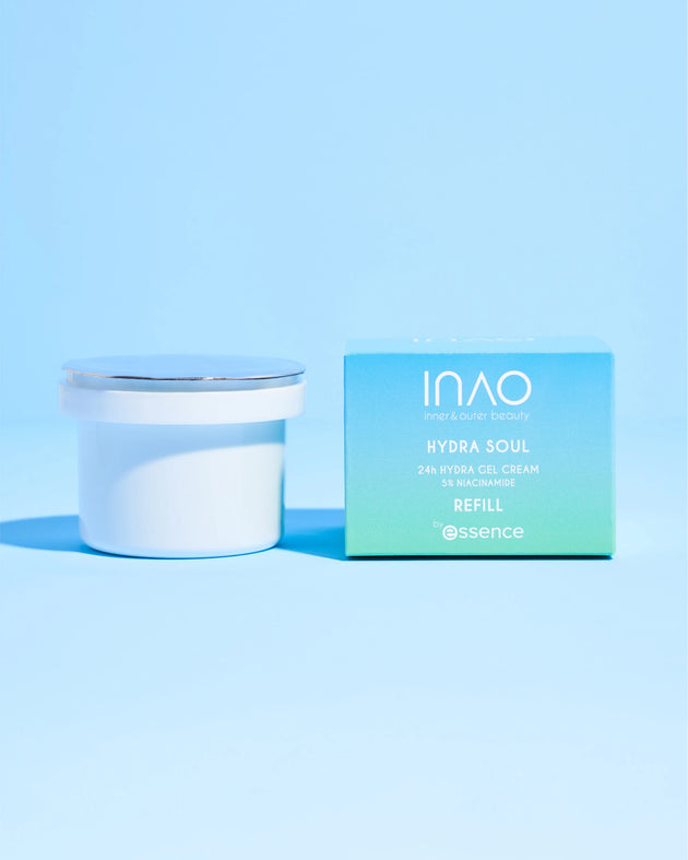 Ein weißer Tiegel mit der Hydra Soul 24h Hydra Gel Cream Refill von INAO by essence mit silbernem Deckel steht neben einer hellblauen Box. Beide bieten intensive Feuchtigkeitsversorgung vor einem passenden hellblauen Hintergrund.
