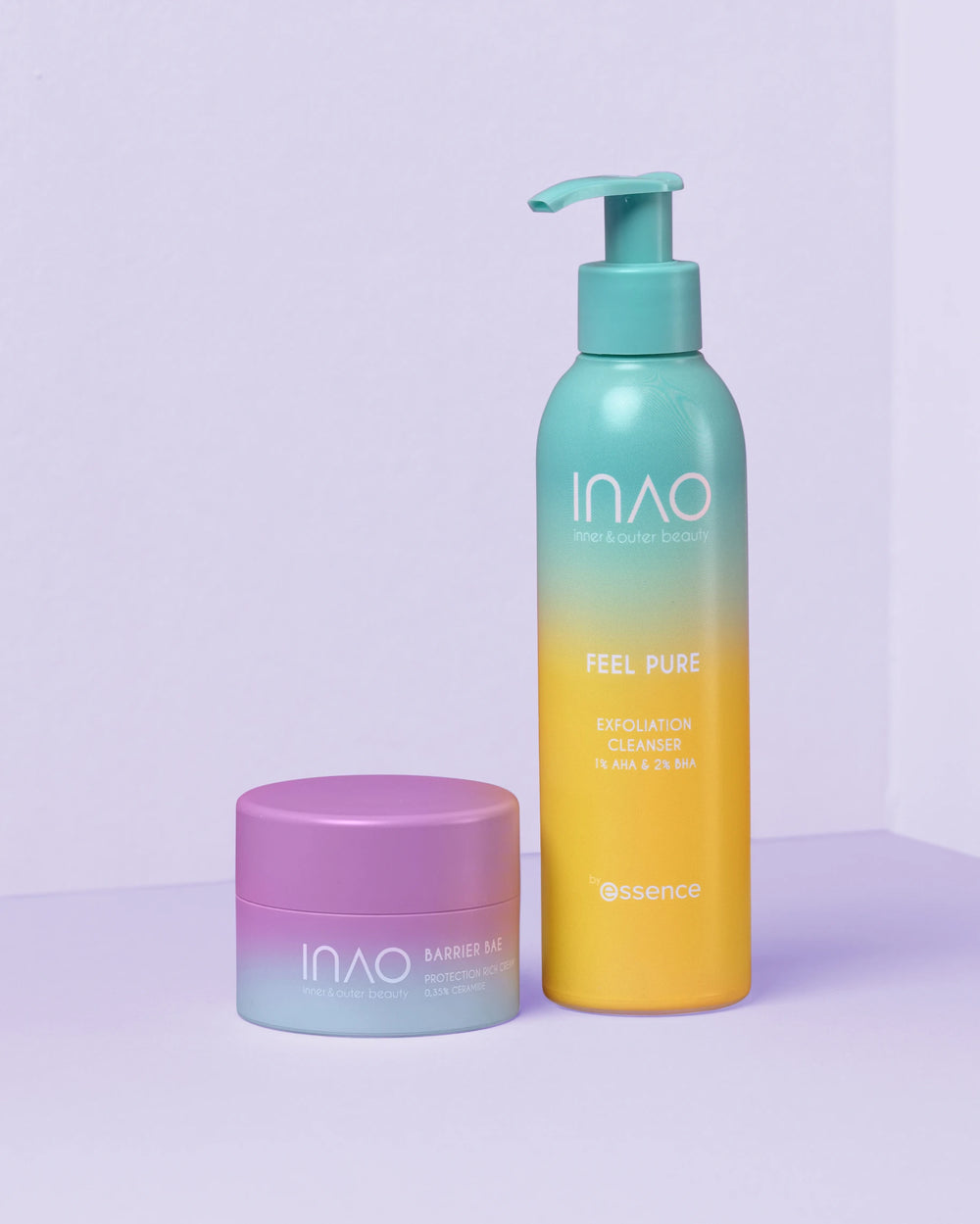 Zwei Pflegeprodukte aus dem Clean & Strong Sparset von INAO by essence auf hellem Untergrund: ein „Barrier Me“ Nachtpflegetiegel mit violettem Deckel und eine gelbgrüne Pumpflasche mit „Feel Pure Exfoliation Cleanser“ – ideal für trockene Haut.