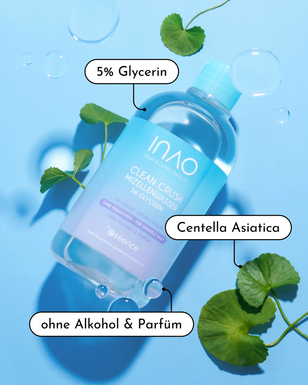 Eine Flasche INAO by essence New Drop Sparset Micellar Water ruht auf einer blauen Fläche mit Centella Asiatica Blättern und Blasen - auf dem Etikett stehen "5% Glycerin", "sanfte Reinigung", "Centella Asiatica" und das New Drop Sparset.