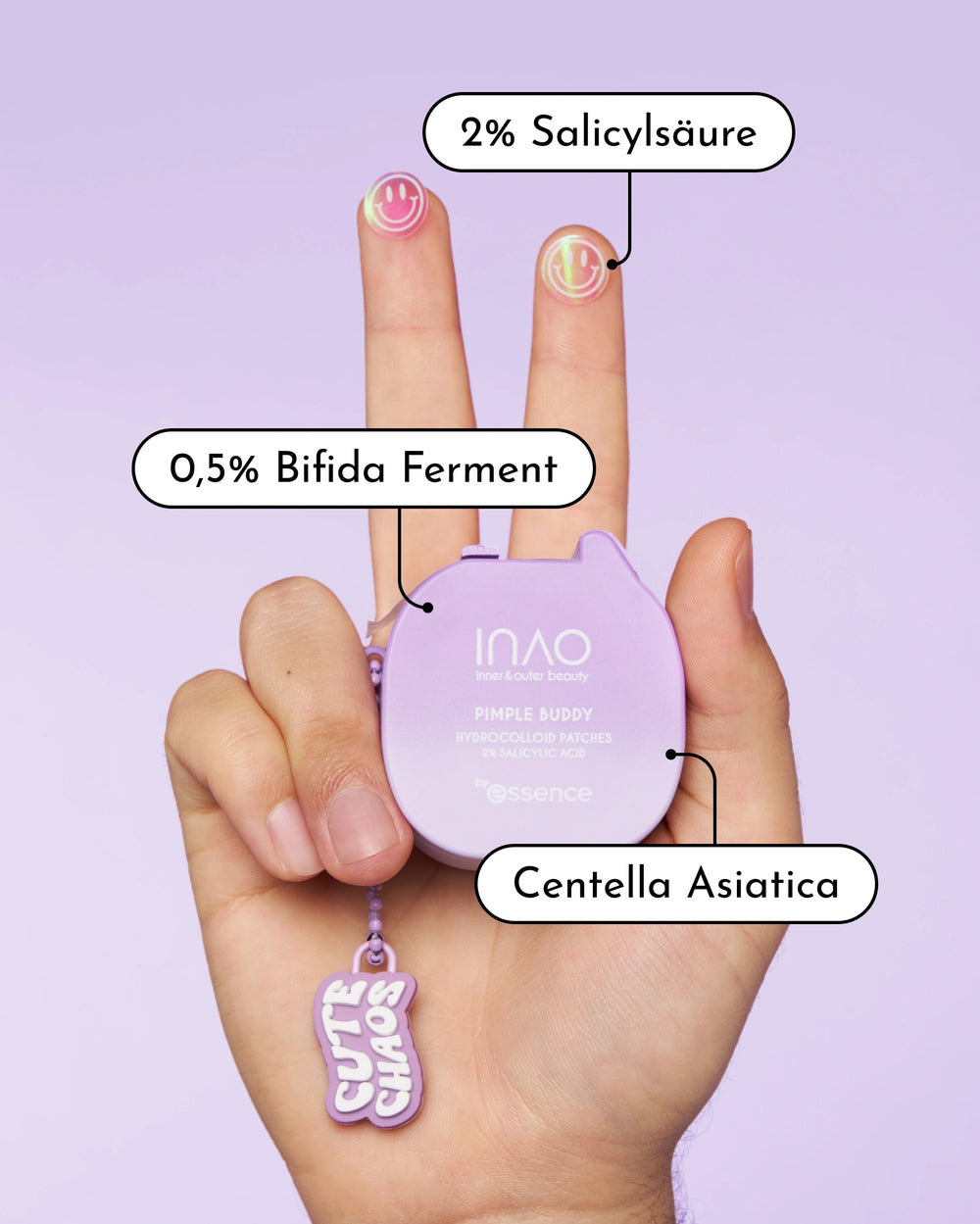 Eine Hand hält ein violettes INAO by essence New Drop Sparset-Gehäuse, auf dem mit zwei Fingern Patches abgebildet sind. Die Etiketten der Inhaltsstoffe zeigen 2% Salicylsäure, 0,5% Bifida Ferment und Centella Asiatica. Darunter baumelt ein "cute chaos"-Schlüsselanhänger.