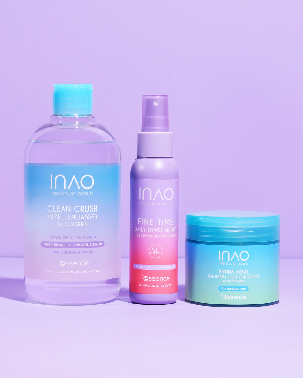 Das INAO New Drop Sparset 2.0 präsentiert auf einer lilafarbenen Oberfläche drei essentielle Hautpflegeprodukte: Mizellenwasser für die sanfte Reinigung, ein Lavendelspray und Hydra Pads für die Tiefenhydratation - alles in einer schicken pastellfarbenen Verpackung.