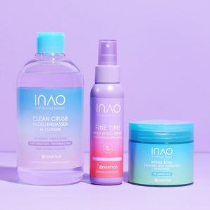 Das INAO New Drop Sparset 2.0 präsentiert auf einer lilafarbenen Oberfläche drei essentielle Hautpflegeprodukte: Mizellenwasser für die sanfte Reinigung, ein Lavendelspray und Hydra Pads für die Tiefenhydratation - alles in einer schicken pastellfarbenen Verpackung.