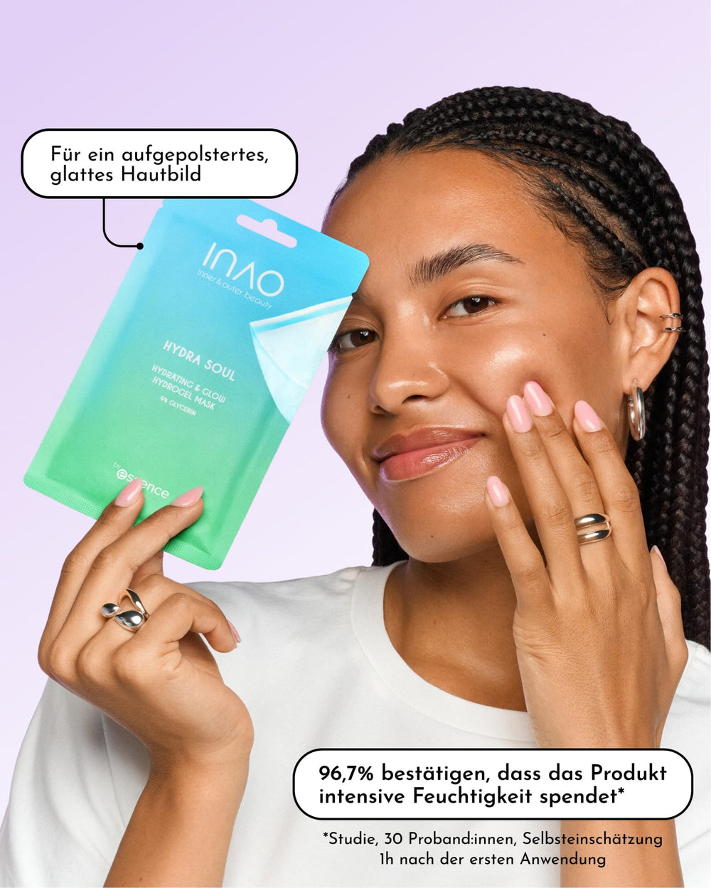 Eine lächelnde Person hält eine grün-blaue Verpackung mit dem Aufdruck „INAO Skincare Must-Haves by essence“ nahe an ihr Gesicht. Ein deutscher Text hebt die feuchtigkeitsspendenden Eigenschaften für die Gesichtspflege hervor. Die Person hat reine Haut, trägt Creolen und ein weißes Oberteil.