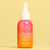 Eine Flasche INAO by essence Light Lover High Protection Serum SPF 50 mit Farbverlauf in Rosa und Orange und einer weißen Tropfkappe steht aufrecht vor einem einfarbig gelben Hintergrund – ideal für einen natürlichen Glanz.