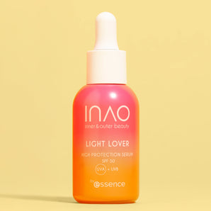 Eine Flasche INAO by essence Light Lover High Protection Serum SPF 50 mit Farbverlauf in Rosa und Orange und einer weißen Tropfkappe steht aufrecht vor einem einfarbig gelben Hintergrund – ideal für einen natürlichen Glanz.