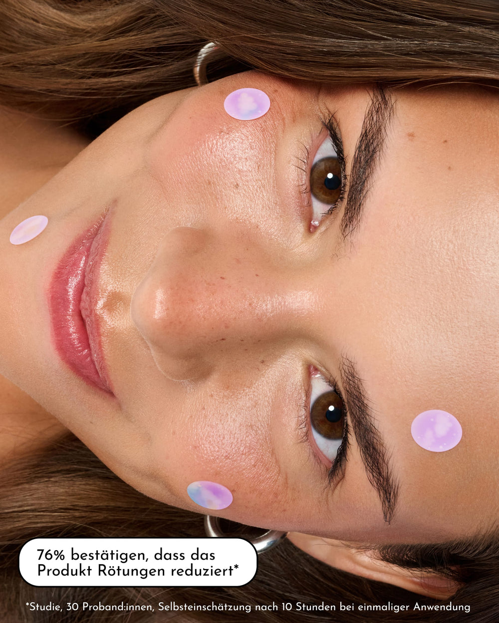 Eine Frau mit reiner Haut ist zu sehen, die die INAO Pimple Buddy Hydrokolloid-Pflaster – Cloud Edition im Gesicht trägt und leicht lächelt. Ein Einblendungstext in deutscher Sprache lautet: „76 % bestätigen, dass das Produkt Rötungen reduziert.“ Außerdem sind weiterer Kleingedrucktes und ein Sternchen zu sehen.
