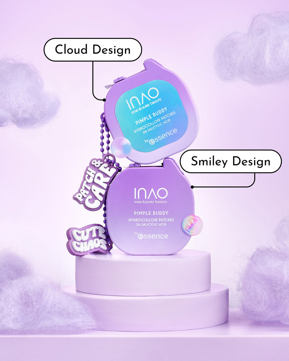 Zwei lilafarbene INAO Pimple Buddy Hydrokolloid-Beutel – einer in Form einer Wolke, der andere mit einem Smiley – liegen auf runden Sockeln. Beide sind beschriftet und mit Cartoon-Anhängern verziert, auf denen „Patch & Care“ und „Cute Chaos“ steht.